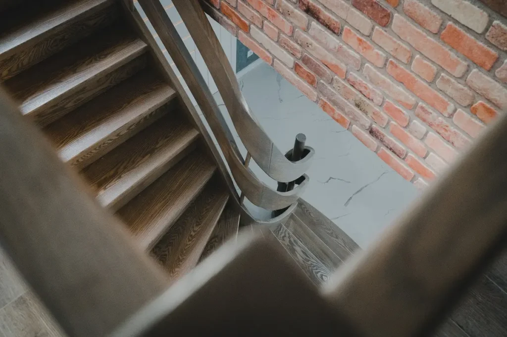 Schody gięte policzkowe z podestem i drewnianą balustradą, zdjęcie 2