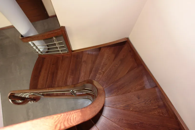 Schody gięte w ciemnym drewnie z balustradą drewno i stal, zdjęcie 4
