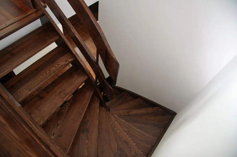 Schody gięte ażurowe w ciemnym drewnie z drewnianą balustradą, zdjęcie 2