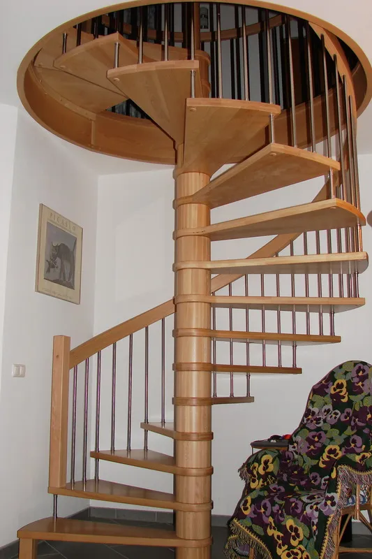 Jasne schody spiralne z metalowymi tralkami i okrągłą galerią, zdjęcie 1