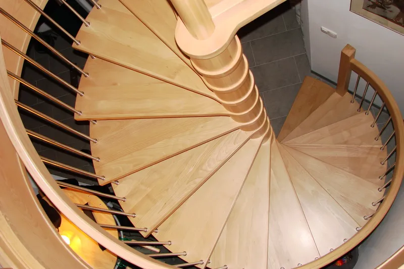 Jasne schody spiralne z metalowymi tralkami i okrągłą galerią, zdjęcie 2